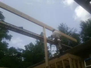 Carpenter setting a ridge beam over a new addition frame — Ice Dam Removal by Roofing Brothers in Lincolnton
