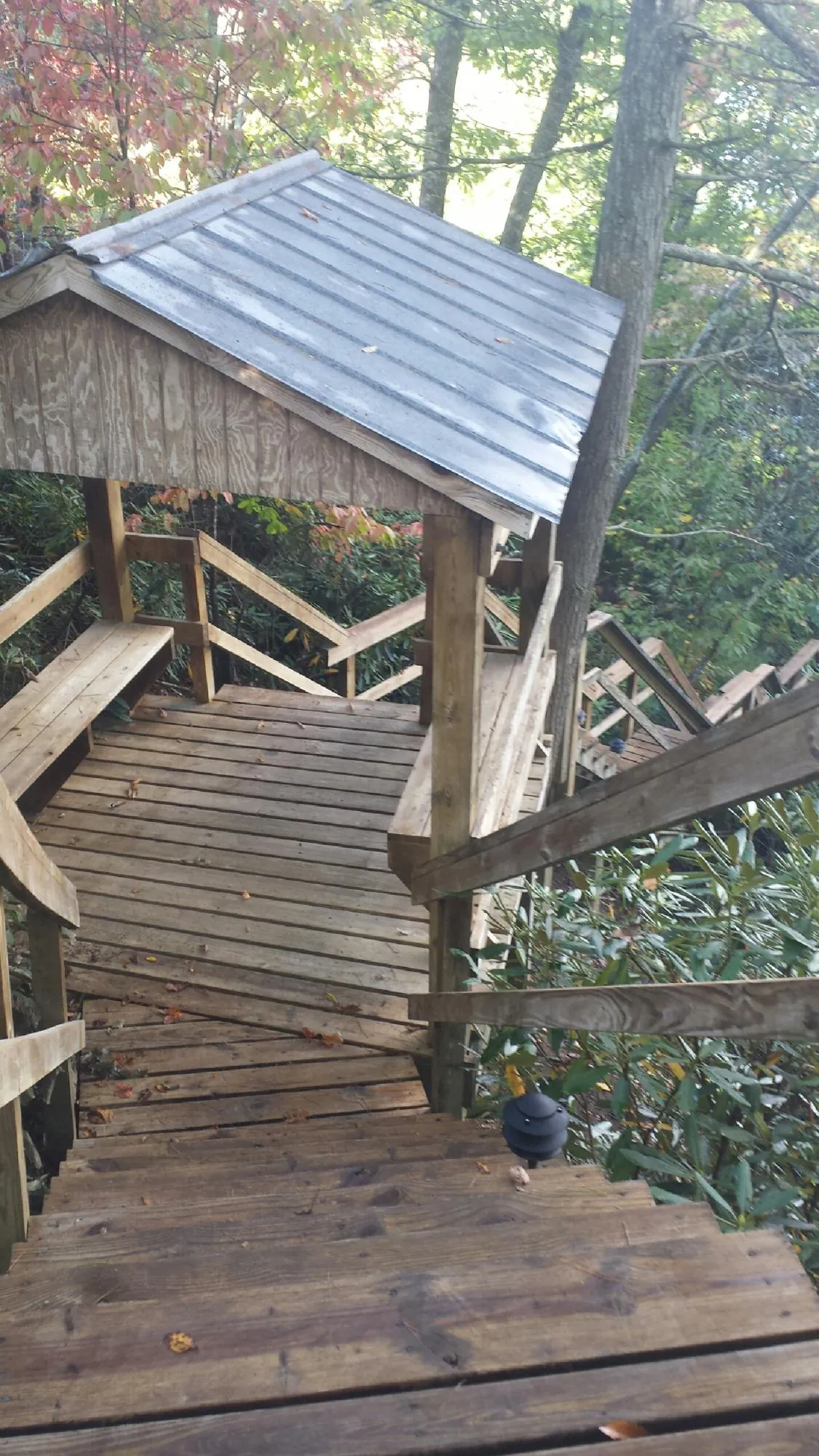 Metal roofed shelter over wooden steps on a wooded walkway — Skylight Repair & Installation work by our crew in Lincolnton